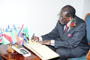 President Mugabe signing the Guest Book